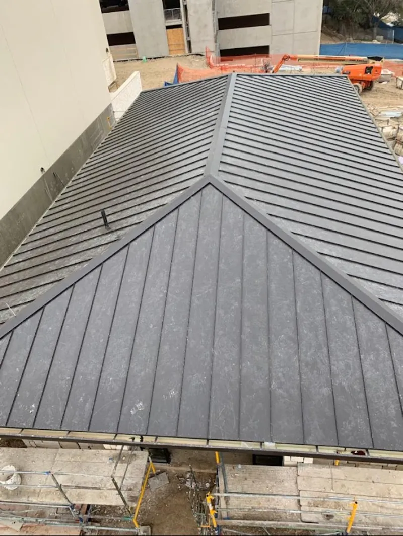 Commercial metal roof construction with crane equipment in Seminole